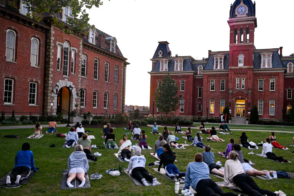 Students doing yoga on the grass of Woodburn Circle